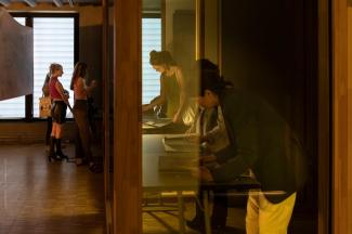 Photo du public lisant des manuscrits dans une salle lors des 10 ans de la Maison de la Recherche