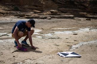 A researcher measures a footprint in the grid area.